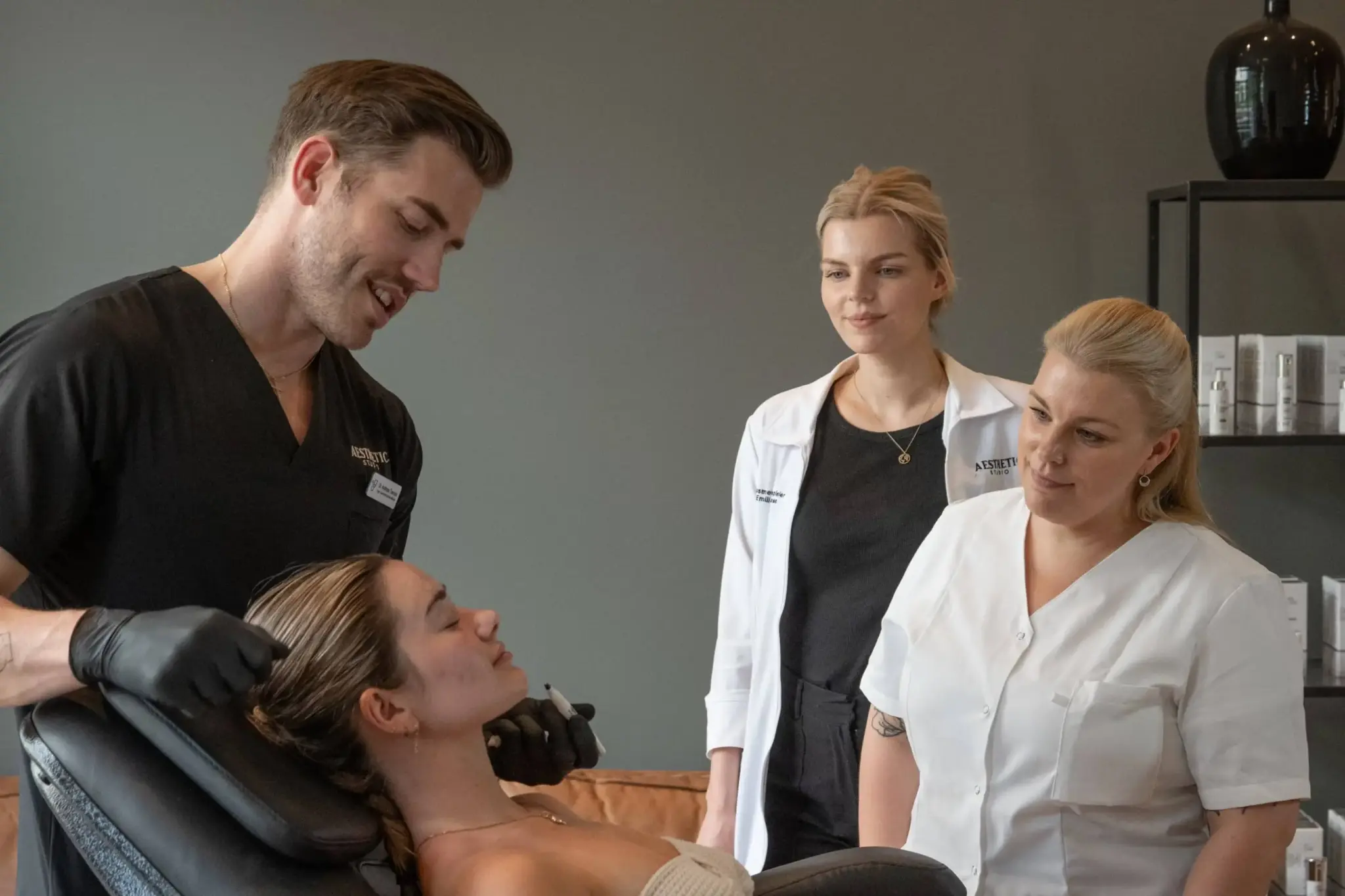 Lege og kursdeltakere gjennomfører praktisk undervisning med fokus på pasientvurdering og trygg utførelse av estetiske behandlinger.