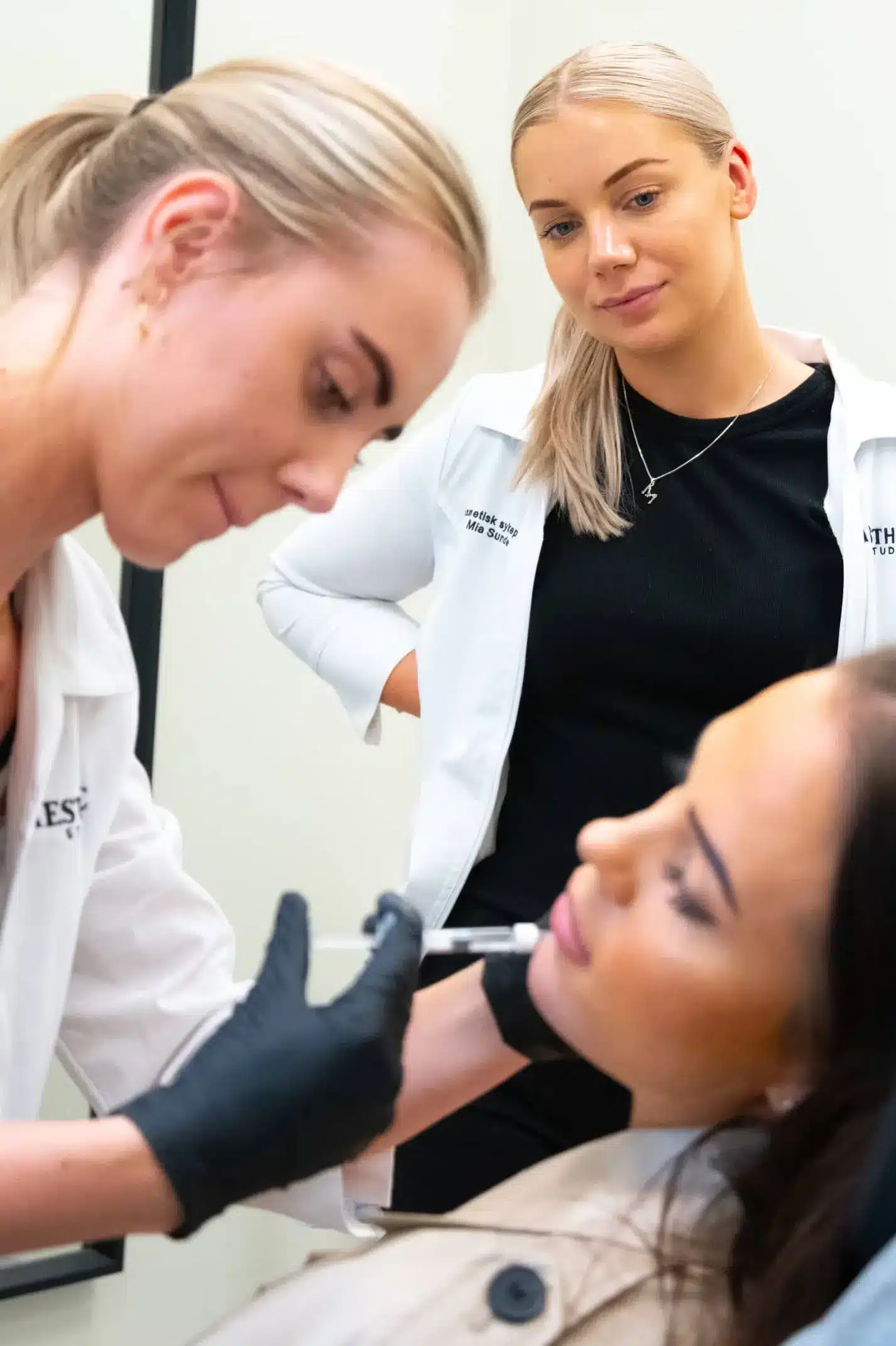 Kursdeltaker utfører injeksjonsbehandling på modell med tett veiledning fra erfaren instruktør under intensivkurs i estetisk medisin.
